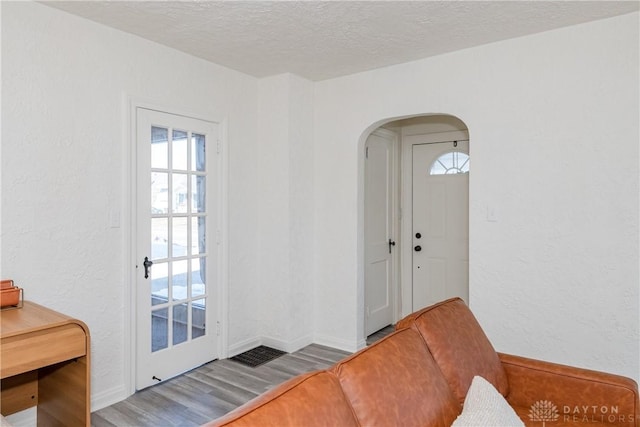 doorway with hardwood / wood-style floors and a textured ceiling