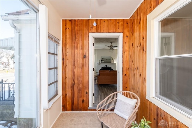 hallway with carpet floors and wooden walls