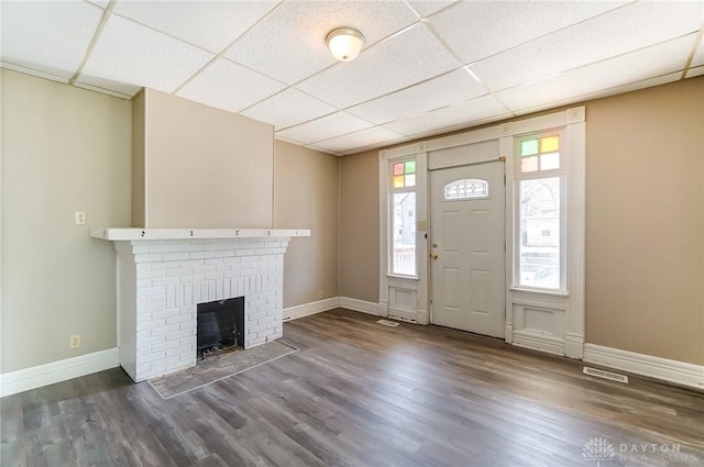 entryway with visible vents, a drop ceiling, a wealth of natural light, and wood finished floors