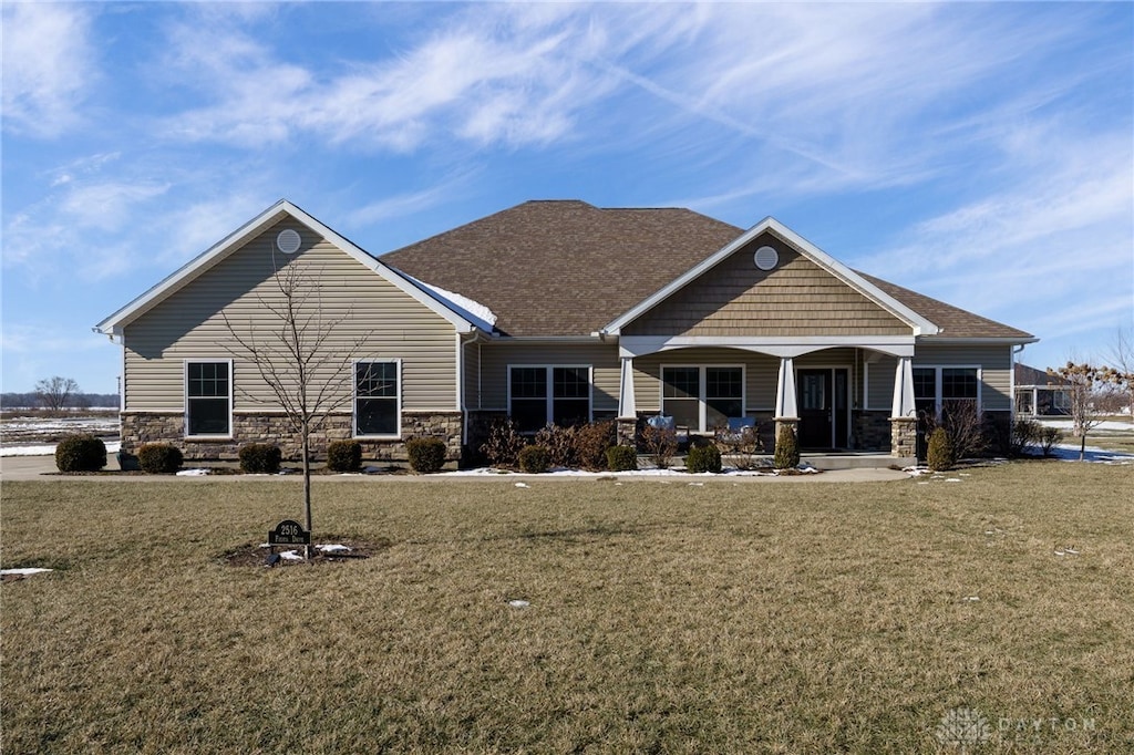 view of front of home with covered porch and a front lawn