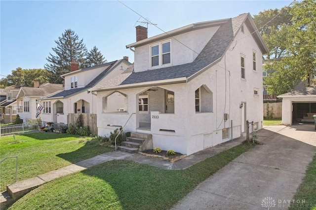 view of front of property with a garage, an outdoor structure, and a front yard