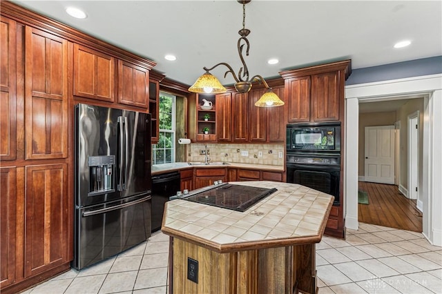 1311 US Route 50, Miami Township, OH 45150 - kitchen featuring black appliances, tile counters, a sink, a center island, and decorative backsplash
