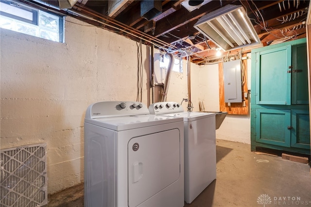 clothes washing area with electric panel and washer and dryer