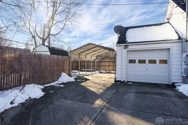 snow covered garage featuring a carport