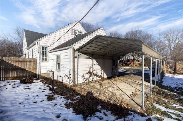 view of snowy exterior featuring a carport