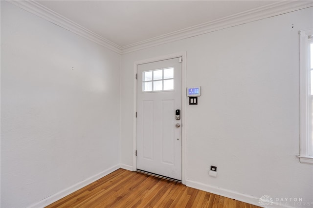 foyer with crown molding and light hardwood / wood-style floors