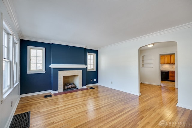 unfurnished living room with ornamental molding, plenty of natural light, and light hardwood / wood-style flooring