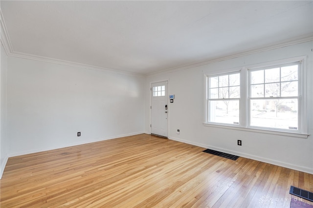 foyer entrance featuring ornamental molding, light hardwood / wood-style floors, and a wealth of natural light