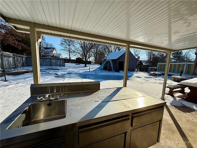 snow covered patio with an outdoor kitchen