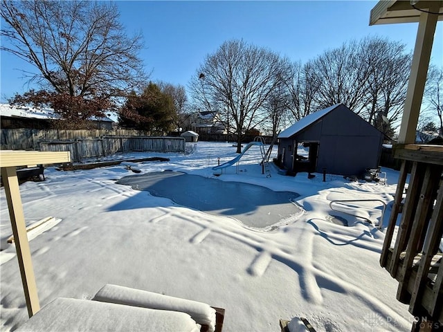 snow covered pool featuring a storage unit