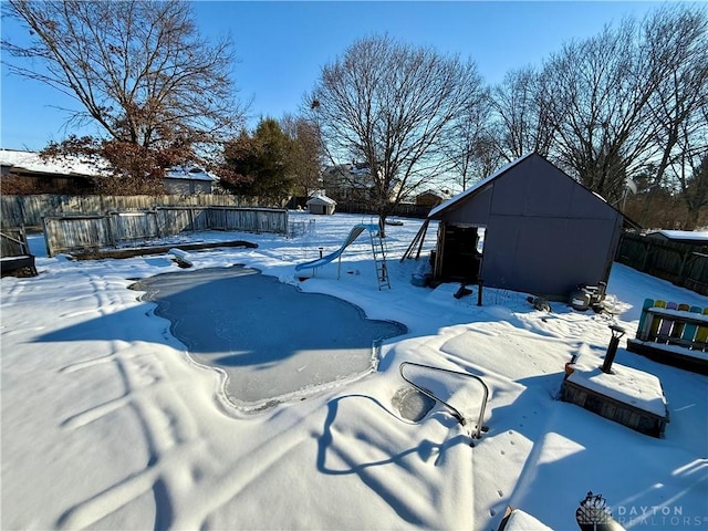 snow covered pool featuring a storage unit