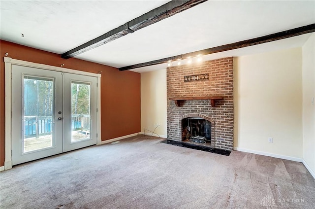 unfurnished living room featuring a brick fireplace, light carpet, beam ceiling, and french doors