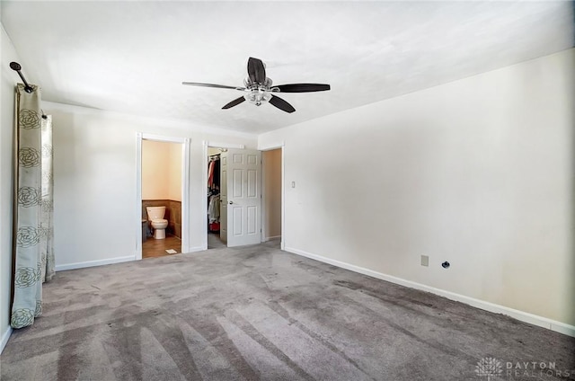 unfurnished bedroom with ensuite bath, ceiling fan, carpet, a spacious closet, and a closet