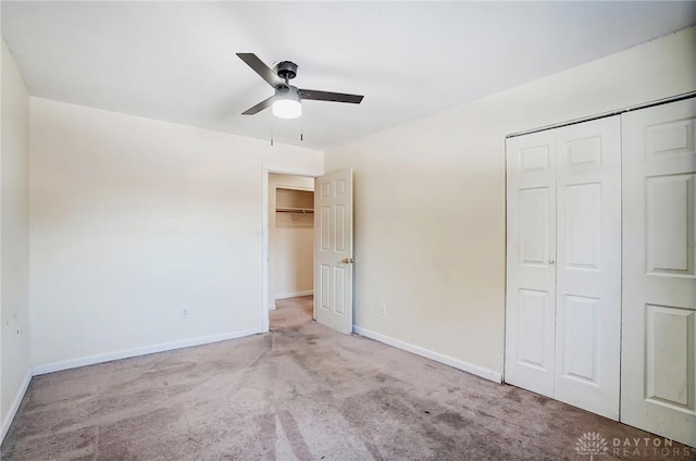 unfurnished bedroom with ceiling fan, light colored carpet, and a closet