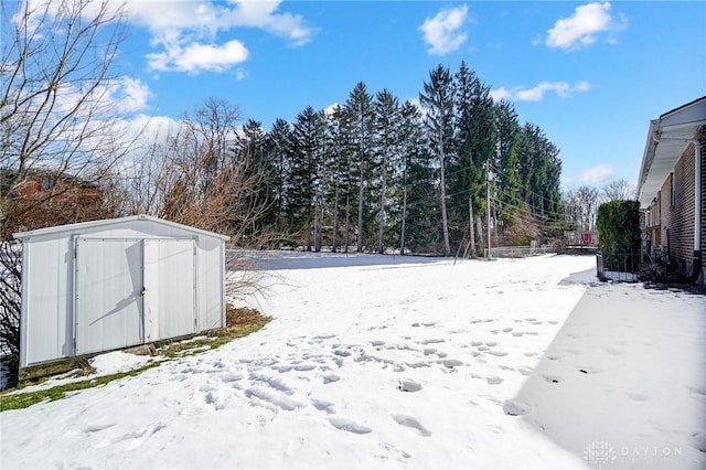 yard covered in snow with a storage unit