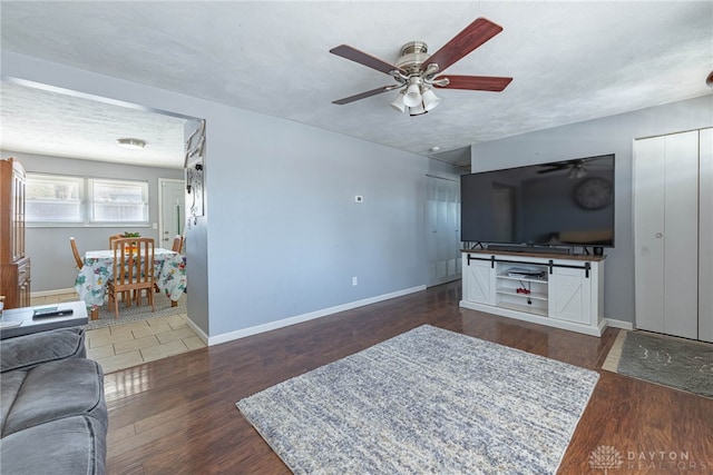 living room with ceiling fan, a textured ceiling, and dark hardwood / wood-style flooring