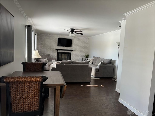 living room with ornamental molding, a brick fireplace, dark hardwood / wood-style floors, and ceiling fan