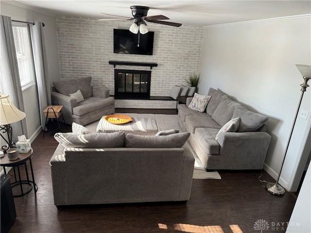 living room featuring dark hardwood / wood-style flooring, a brick fireplace, ornamental molding, and ceiling fan