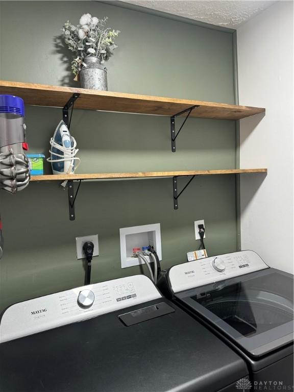 washroom featuring washer and clothes dryer and a textured ceiling