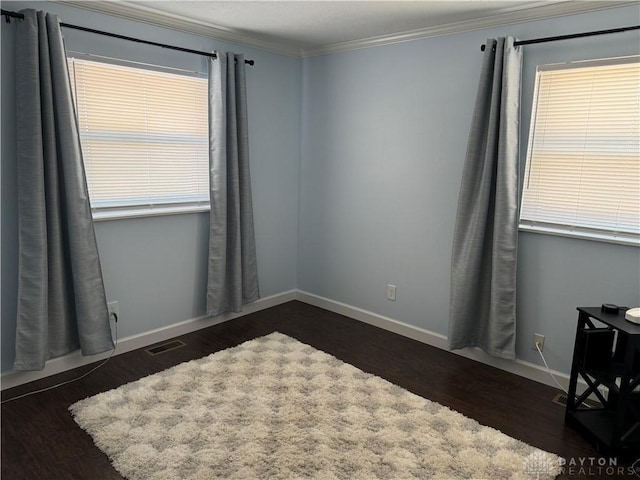 spare room featuring crown molding and dark wood-type flooring