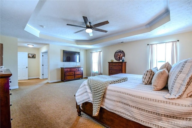 bedroom featuring ceiling fan, a raised ceiling, crown molding, light carpet, and a textured ceiling