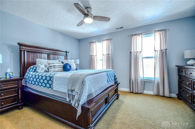 carpeted bedroom featuring a textured ceiling and ceiling fan