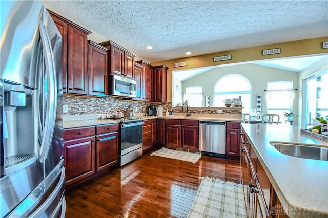 kitchen with sink, decorative backsplash, a textured ceiling, and appliances with stainless steel finishes