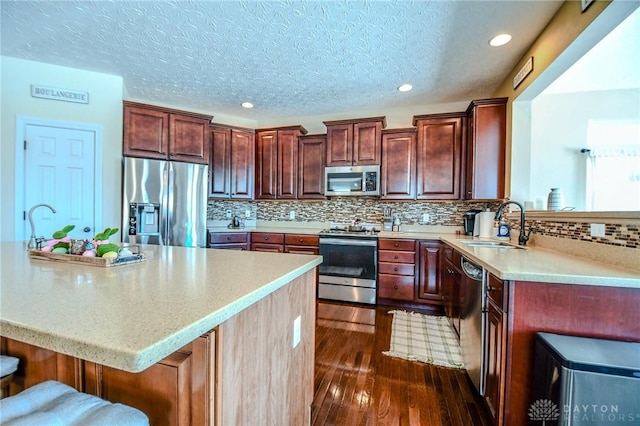 kitchen with sink, backsplash, a breakfast bar area, and appliances with stainless steel finishes