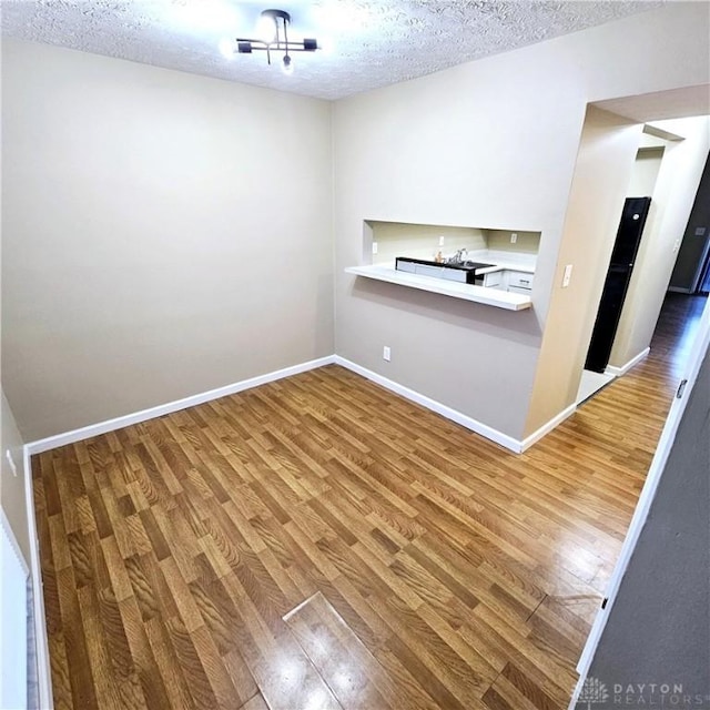 empty room featuring hardwood / wood-style flooring and a textured ceiling