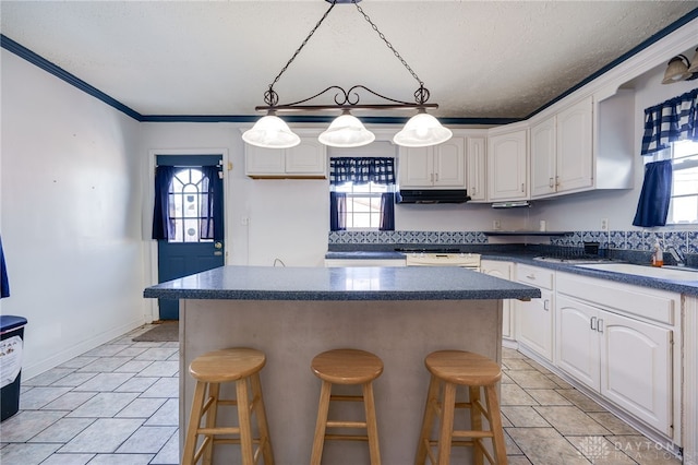 kitchen with white cabinetry, a kitchen island, and a wealth of natural light