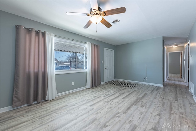 empty room with ceiling fan and light hardwood / wood-style floors