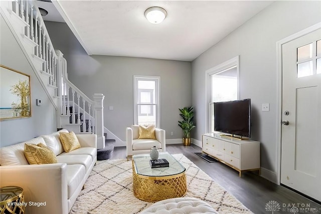 living room with plenty of natural light and dark hardwood / wood-style flooring