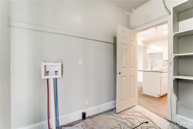 washroom featuring sink, hookup for a washing machine, and light hardwood / wood-style floors