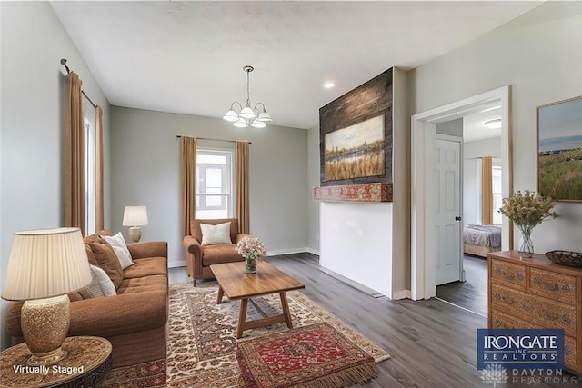 living room with dark wood-type flooring and a chandelier