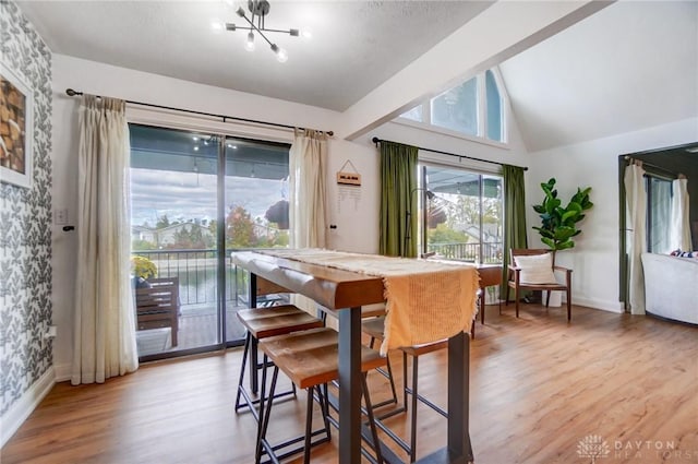 dining space featuring vaulted ceiling and light wood-type flooring