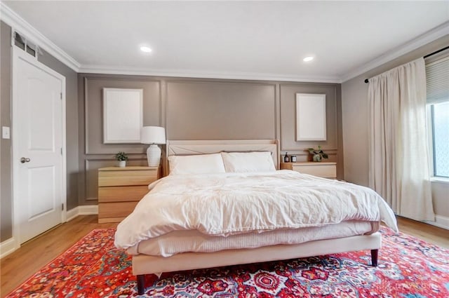 bedroom featuring crown molding and light hardwood / wood-style flooring