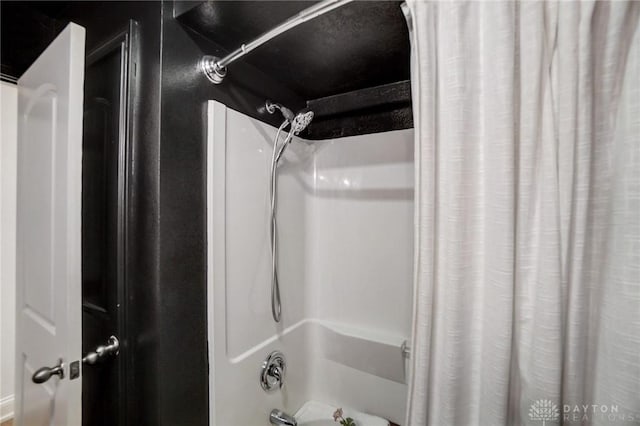 bathroom with shower / bath combo with shower curtain