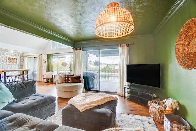 living room with ornamental molding, lofted ceiling, and hardwood / wood-style floors