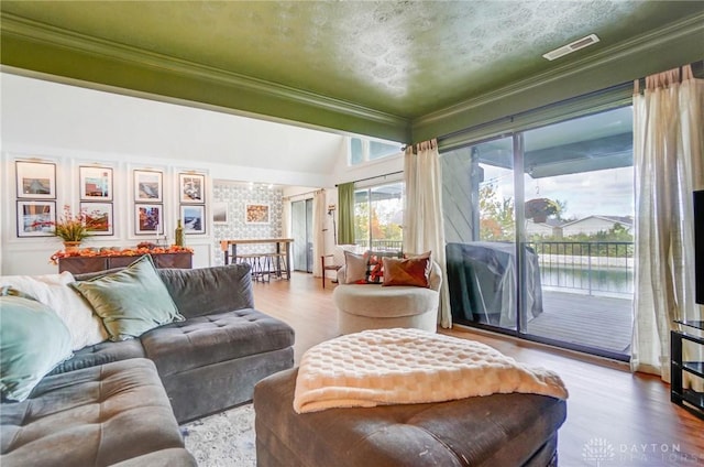 living room featuring crown molding, lofted ceiling, and hardwood / wood-style floors