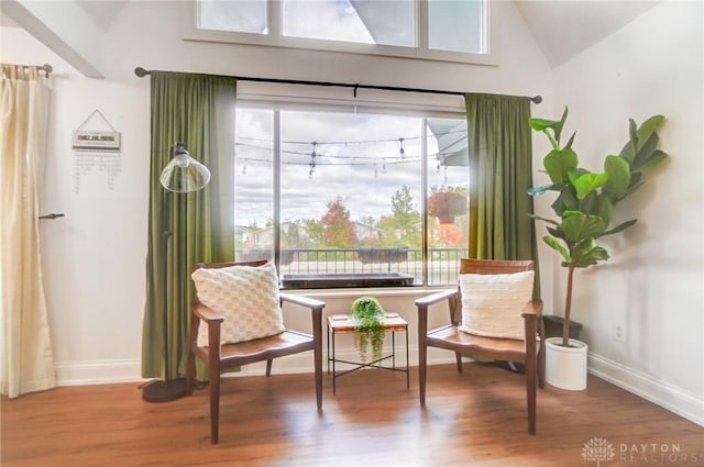 sitting room featuring vaulted ceiling and hardwood / wood-style floors