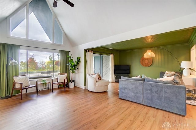 living room with hardwood / wood-style floors, high vaulted ceiling, and ceiling fan