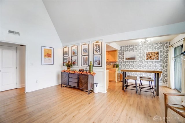 interior space featuring lofted ceiling and light hardwood / wood-style flooring