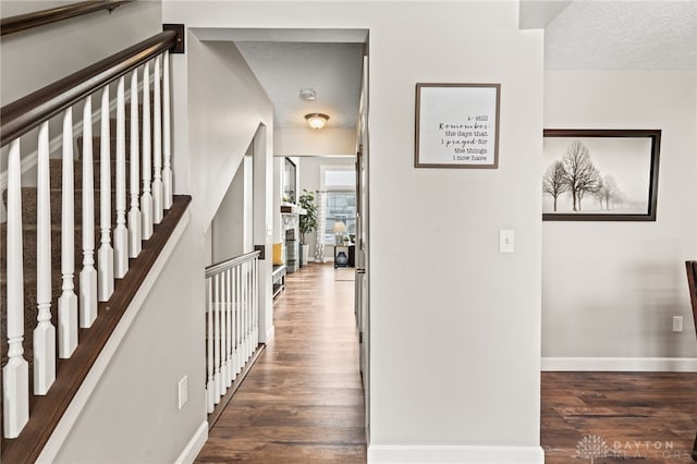 hall with dark hardwood / wood-style floors and a textured ceiling