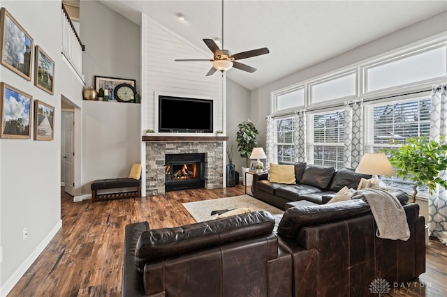 living room with hardwood / wood-style flooring, a stone fireplace, high vaulted ceiling, and ceiling fan