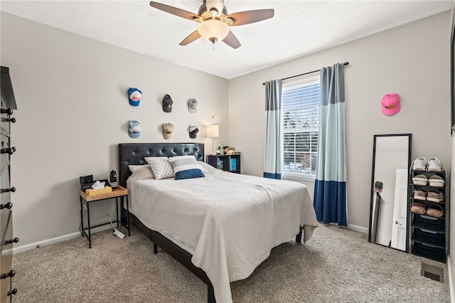 bedroom featuring light carpet, ceiling fan, and a textured ceiling