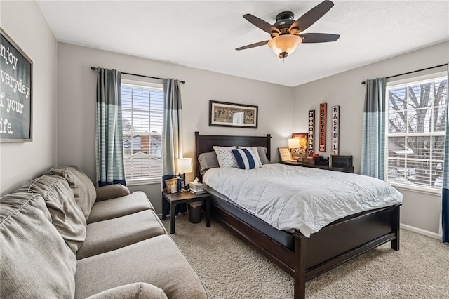 carpeted bedroom featuring ceiling fan and a textured ceiling