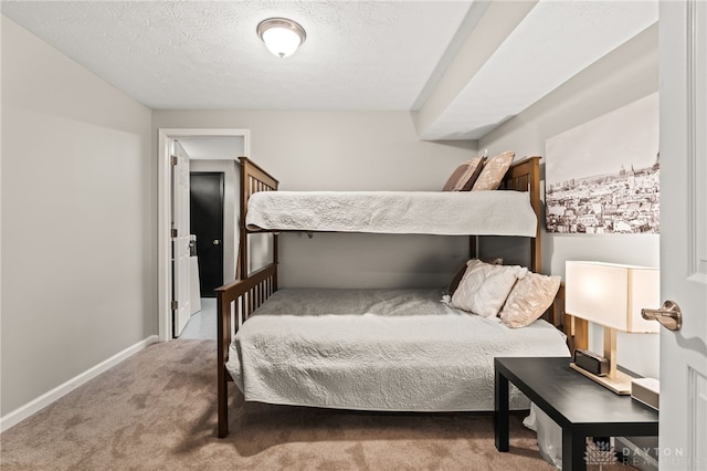 bedroom featuring light carpet and a textured ceiling