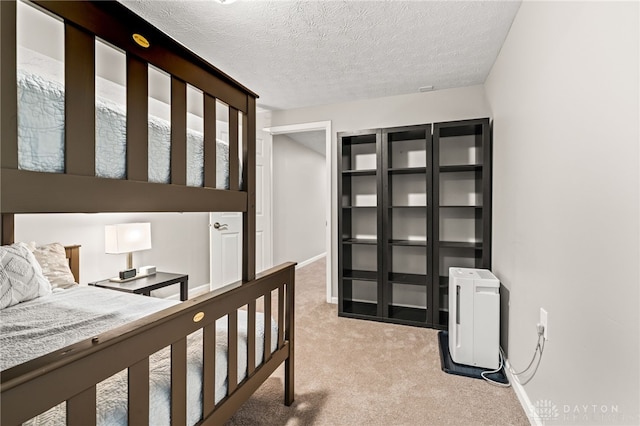 bedroom featuring light colored carpet and a textured ceiling