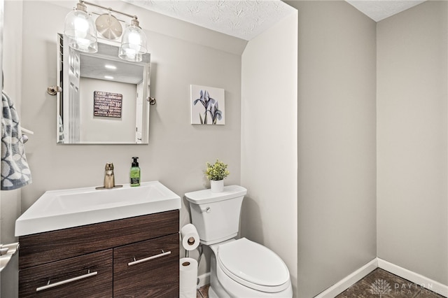 bathroom with vanity, a textured ceiling, and toilet