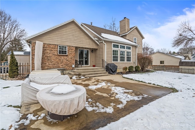 view of snow covered rear of property